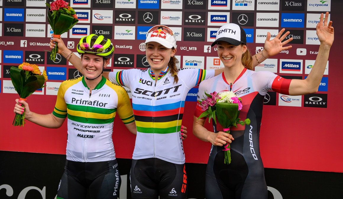Bec McConnell y Kate Courtney compartiendo podio en el short track de Nove Mesto 2019 junto con Haley Smith